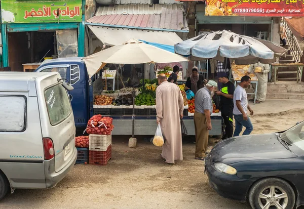 Amman, Jordan, Ekim 04, 2023: Ürdün, Tabqet Fahel 'de bir otoyolda arabasının yanında sebze ve meyve satan bir sokak satıcısı