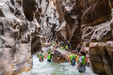 Kerak, Ürdün, 07 Ekim 2023: Mujib Nehri 'nin Ürdün' deki Mujib el-Mujib Kanyonu 'ndaki yüksek uçurumlar arasında akan engellerin üstesinden gelen çok sayıda aşırı turist