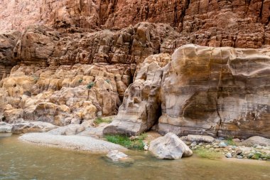 Ürdün, Wadi Al Mujib 'deki Mujib Nehri Kanyonu' ndaki turizm rotasının başlangıcında dağ kayalarının renkleri çeşitliydi.