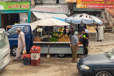 Amman, Jordan, Ekim 04, 2023: Ürdün 'deki Tabqet Fahel şehrinde bir otoyolda arabasının yanında sebze ve meyve satan bir sokak satıcısı