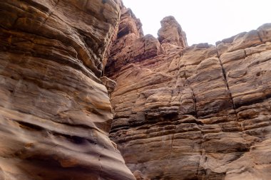 Ürdün, Wadi al Mujib 'deki Mujib Nehri' nin kanyonundaki turizm rotasının sonundaki dağların doğal renklendirilmesi tuhaftır.