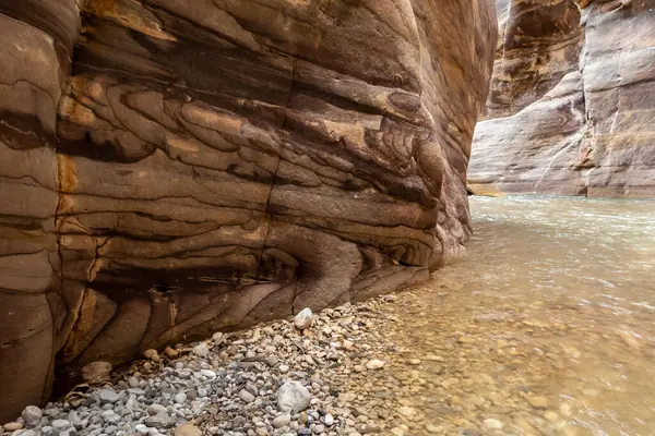 Ürdün, Wadi al Mujib 'deki Mujib Nehri' nin kanyonundaki turizm rotasının sonundaki dağların doğal renklenmesi tuhaftır.