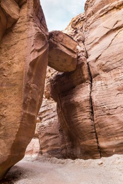 Büyük bir taş düştü ve Ürdün 'deki Wadi Numeira vadisi boyunca yürüyüş rotası boyunca vadideki kayaların arasına sıkıştı.