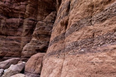 Bizarre natural stripes on rock walls along a shallow stream along the Wadi Numeira hiking trail in Jordan