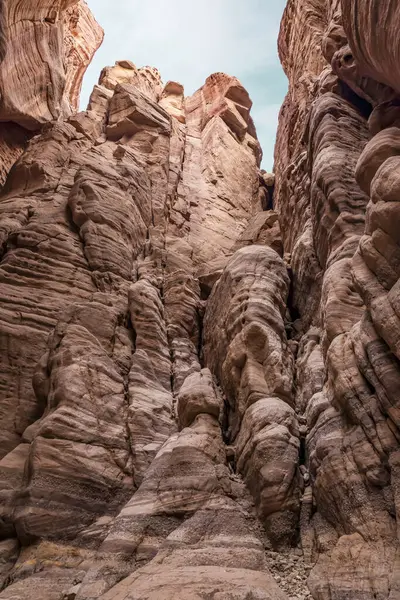 Tall rocks painted with beautiful natural patterns along the walking trail in the Wadi Numeira gorge in Jordan