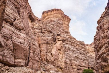 Ürdün 'deki Wadi Numeira vadisinde yürüyüş yolunun sonunda doğal desenleri olan yüksek kayalar.