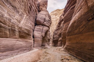 Ürdün 'deki Wadi Numeira vadisinin sonundaki yürüyüş yolunun sonunda duvarlarında güzel desenler olan yüksek kayalar arasında küçük sığ bir dere akıyor.
