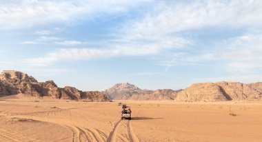 Amman, Ürdün, Ekim 06, 2023: Turistler Ürdün 'deki Amman yakınlarındaki Wadi Rum' un engin kırmızı çölü boyunca beyaz Toyota ihalesine biniyorlar.