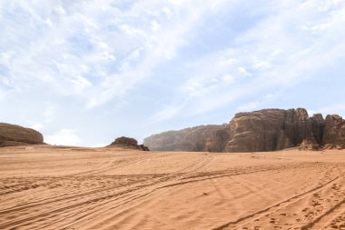Ürdün 'de Amman yakınlarında Wadi Rum' un sonsuz kumlu kırmızı çölünde Jeep izleri var.