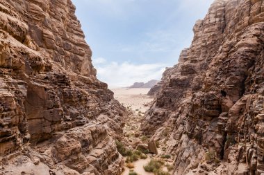 Ürdün 'deki Amman yakınlarındaki Wadi Rum' un kırmızı çölünde yüksek dağların çerçevelediği güzel bir vadi.