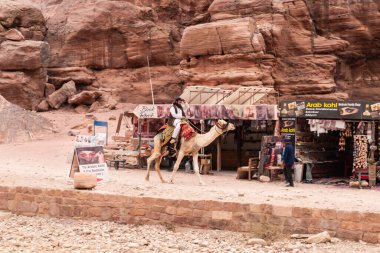 Wadi Musa, Ürdün, 05 Ekim 2023: Ürdün 'de Wadi Musa şehrindeki Petra Krallığı' nda Bedevi deve ile hediyelik eşya dükkanlarının yakınına gidiyor.