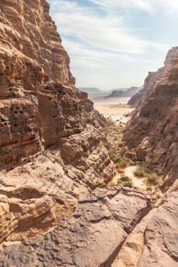 Ürdün 'deki Amman yakınlarındaki Wadi Rum' un kırmızı çölünde yüksek dağların çerçevelediği güzel bir vadi.