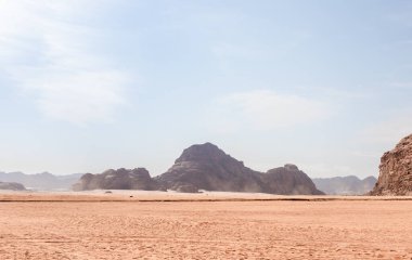 Ürdün 'deki Amman yakınlarındaki Wadi Rum' un sonsuz kırmızı çölünde dağların alçak tepeleri.