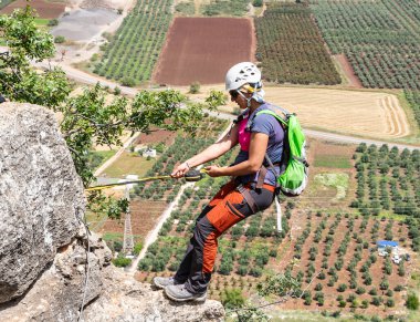 Tiberias, İsrail, 23 Nisan 2024: Özel ekipmanlı profesyonel atlet İsrail 'in kuzeyindeki Tiberias yakınlarındaki dağlarda Via Ferrata Ravid rotasındaki bir kayaya bağlı duruyor.
