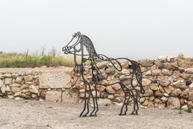 Yokneam, İsrail, 26 Nisan 2024: İsrail 'in kuzeyindeki Yokneam kenti yakınlarındaki Megiddo sahasının Kenan Kalesi kazılarında koşumlu bir atın demir figürü