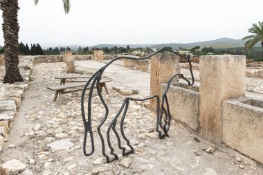 Yokneam, Israel, April 26, 2024 : Iron model of a horse in remains of a stone stall at excavation of the Canaanite Fortifications of the Megiddo site near Yokneam city in the northern Israel clipart