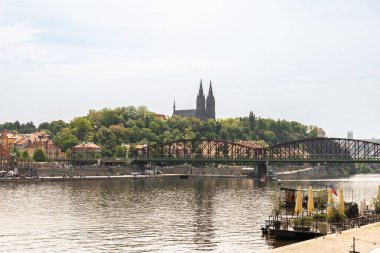 Prag, Çek Cumhuriyeti, 11 Mayıs 2024: Çek Cumhuriyeti 'nin Vysehrad kentinde Vltava Nehri' nin setinden Demiryolu Köprüsü ve Aziz Peter ve Paul Bazilikası 'na bakın