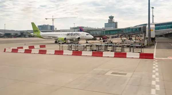 stock image Prague, Czech Republic, May 11, 2024 : Early morning view from window of Smart Wings plane of Air Baltic plane parked at terminal of Prague airfield in Czech Republic