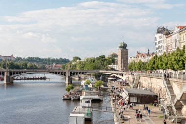Prag, Çek Cumhuriyeti, 11 Mayıs 2024: Vltava Nehri üzerindeki Irasekov Köprüsü ve Çek Cumhuriyeti 'ndeki Prag' da antik evlerin bulunduğu set