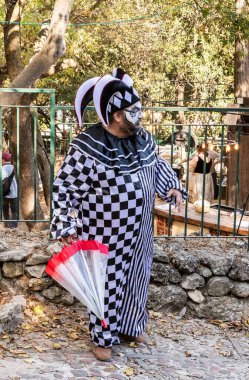 Kudüs, İsrail, Ekim 03, 2024: Kareli takım elbiseli sanatçı, Kudüs İsrail 'de düzenlenen 2024 Kudüs Şövalyeleri festivalinde şemsiyeli.