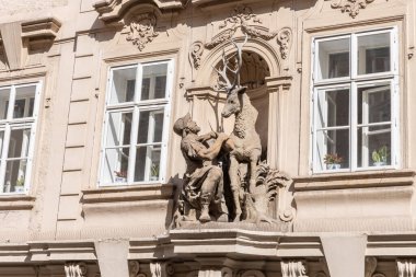 Prag, Çek Cumhuriyeti, 12 Mayıs 2024: Çek Cumhuriyeti 'nin tarihi bölümünde Prag' da eski bir evin cephesinde bir avcı ve bir geyiği tasvir eden heykel