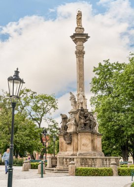 Prague, Czech Republic, May 12, 2024 : The Marian Plague Column in garden on Hradcanska Square in Prague in Czech Republic clipart