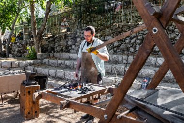 Jerusalem, Israel, October 03, 2024 : Blacksmith shows how iron was forged in Middle Ages at the annual festival Jerusalem Knights 2024 in Jerusalem Israel clipart