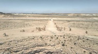 İsrail 'in güneyindeki Mitzpe Ramon yakınlarındaki Judean Çölü' nün üzerindeki çöldeki kamu heykel parkında özel bir desen oluşturulmuş büyük kaya parçalarının insansız hava aracı görüntüsü..