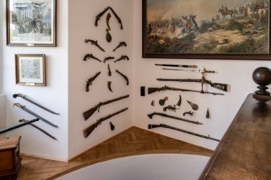 Prague, Czech Republic, May 13, 2024 : Living room walls with paintings and guns in Cesky Sternberk castle an hours drive from Prague clipart