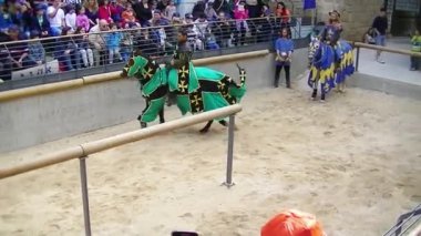 Acre, İsrail, 09 Nisan 2015: Ortaçağ şövalyesi gibi giyinmiş bir aktör, İsrail 'in Acre kentindeki yıllık gösteride izleyicilerin önünde at sırtında yeşil biniyor.