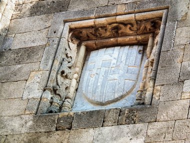 Yunanistan 'ın Rodos adasındaki Rodos şehrinin tarihi bölümünde duvarlara taştan oyulmuş kısmen korunmuş hanedan armaları