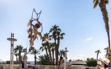 Eilat, İsrail, 18 Ekim 2024: Denizkızı kılığındaki hava akrobatı, İsrail 'in güneyindeki Eilat toprak setindeki canlı heykeller festivalinde gösteri yapıyor