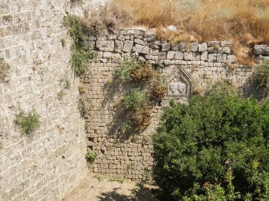 Well preserved bas relief carved from the stone on surface of fortress walls in historic part of Rhodes city on Rhodes island in Greece clipart