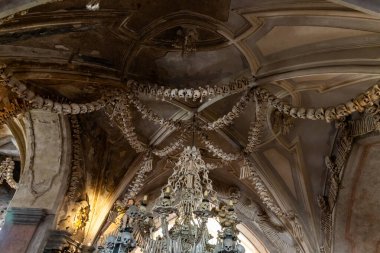 Kutna Hora, Çek Cumhuriyeti, 13 Mayıs 2024: Çek Cumhuriyeti 'nin Kutna Hora kentindeki Kostnice Sedlec Gotik Şapeli' nin ana salonundaki insan kemiği ve kafataslarının çelenkleri tavandan sarkıyor