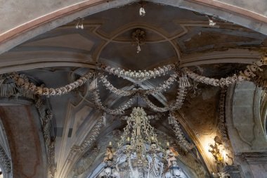 Kutna Hora, Çek Cumhuriyeti, 13 Mayıs 2024: Çek Cumhuriyeti 'nin Kutna Hora kentindeki Kostnice Sedlec Gotik Şapeli' nin ana salonunun tavanında insan kemiği ve kafatasları asılı.
