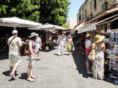Rodos, Yunanistan, 02 Temmuz 2011: Yunanistan 'ın Rodos adasındaki Rodos kentinin tarihi kesiminde Sokratous Caddesi boyunca çok sayıda turist yürüyor