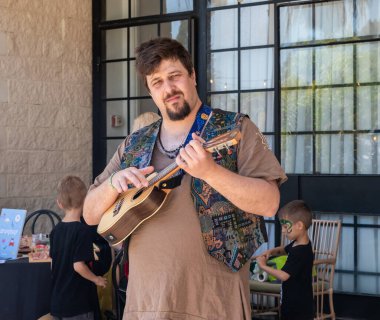 Petah Tikva, İsrail, 18 Nisan 2025: İsrail 'in Petah Tikva kentindeki bahar şövalyeleri festivalinde minyatür Hawaii gitarı Ukulele çalan adam