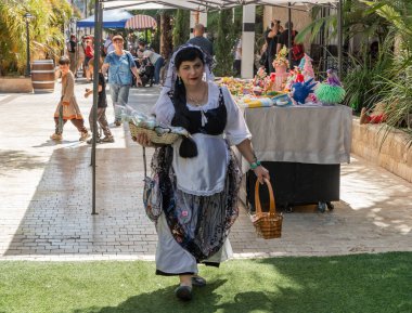 Petah Tikva, İsrail, 18 Nisan 2025: Ortaçağ kostümü giyen satıcı İsrail 'deki Petah Tikva' da bahar şövalyeleri festivalinde şeker dağıtıyor
