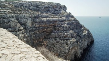 Kayalar, Malta 'daki Akdeniz' deki Blue Grotto üzerinde yükseliyor.