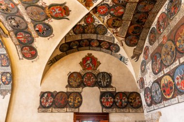 Prag, Çek Cumhuriyeti, 14 Mayıs 2024: Çek Cumhuriyeti 'nin Prag kentindeki Eski Kraliyet Sarayı' nın üst katındaki cephanelik odasının tavanına ve duvarlarına kraliyet arması boyanmış.