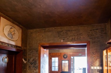 Prag, Çek Cumhuriyeti, 14 Mayıs 2024: Çek Cumhuriyeti 'nin Prag kentindeki U Kalicha Shveik restoranına ziyaretçilerin resim ve çizimleriyle dolu duvarlar