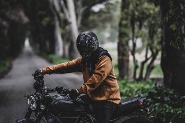 Ormanda motosikletli genç bir adam.