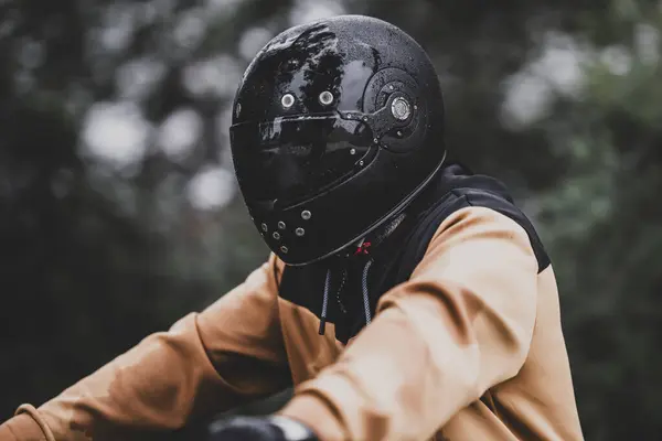 Genç sakallı bisikletçi, kask takıyor ve yüzü eldivenli.