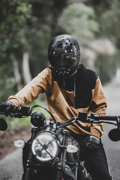 Şehirde motosiklet süren bir adam.