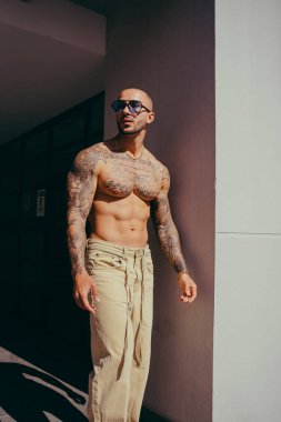 Sokakta poz veren kaslı sakallı genç bir adam.