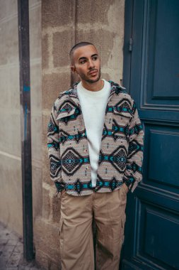 Dışarıda poz veren sıradan giysili yakışıklı bir Afrikalı.