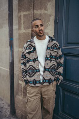 Şehir sokaklarında poz veren sıradan giyinmiş yakışıklı bir adamın portresi.