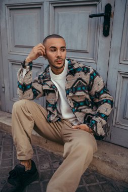 Şehirde oturan yakışıklı bir gencin portresi.