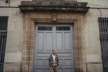 Bir binanın önünde duran adam.