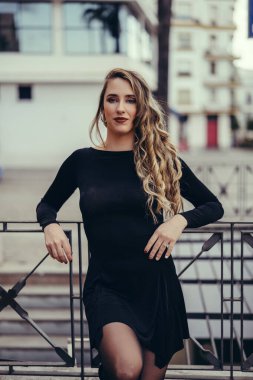 Siyah elbiseli ve siyah elbiseli sarışın bir kızın portresi.